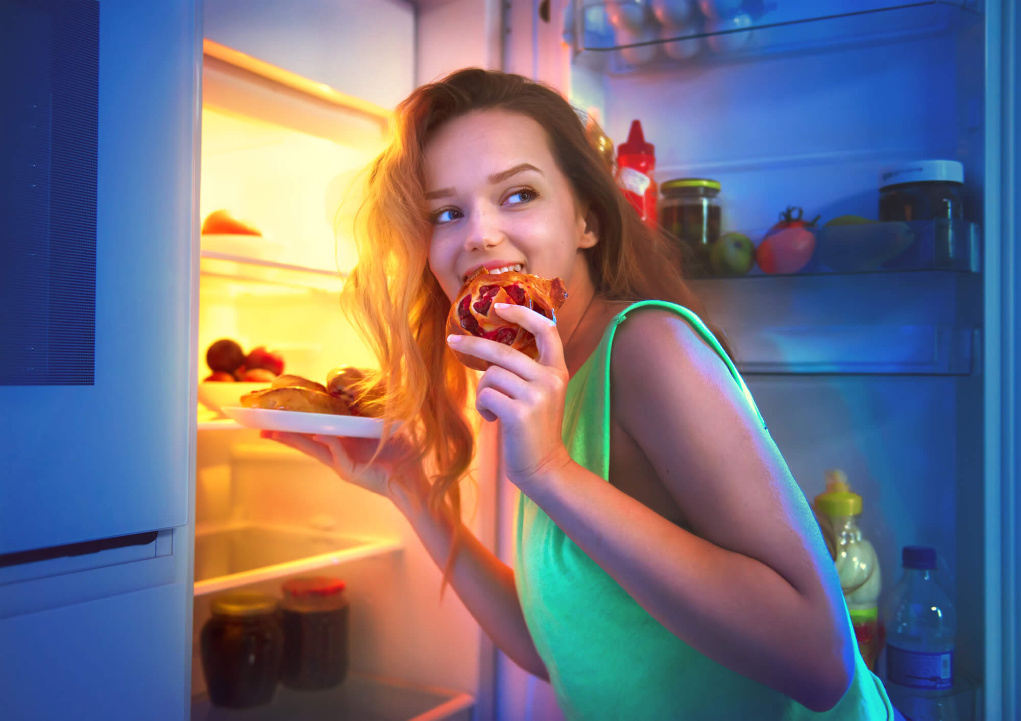Dziewczyna bierze jedzenie z lodówki w nocy